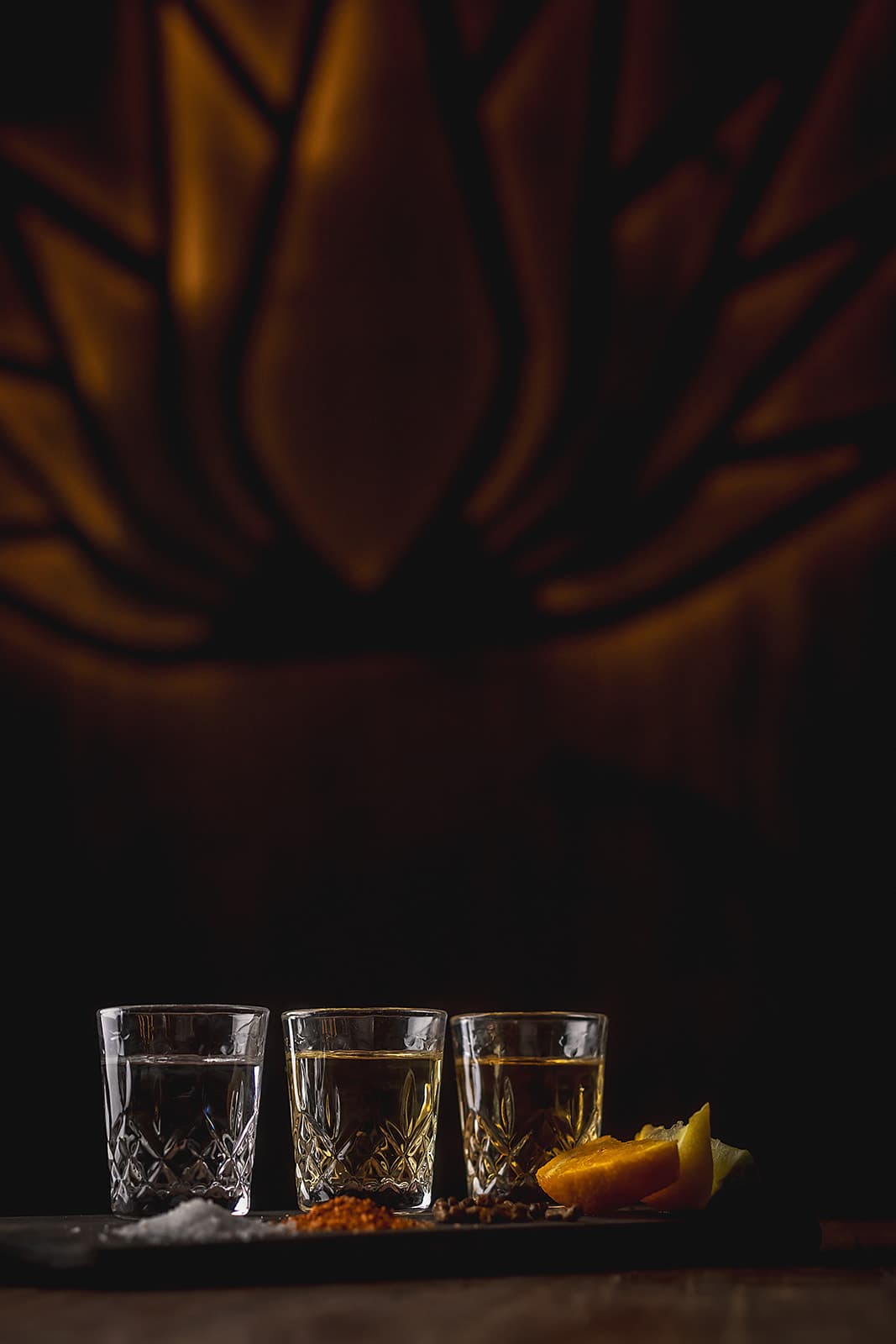 A tequila tasting flight beneath warm agave-inspired lighting