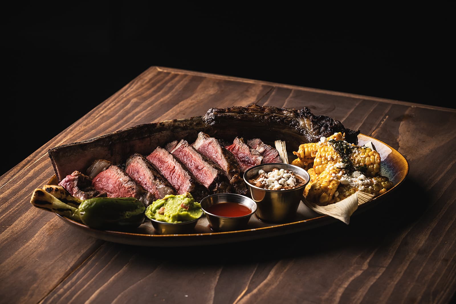 Sliced MDA tomahawk with elote and salsa